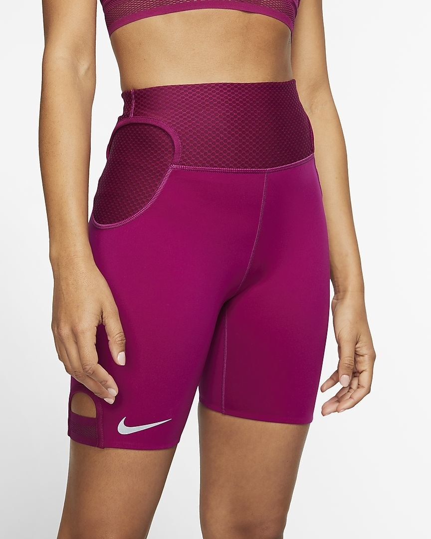 Model in the magenta bike shorts with mesh around the waist and a cutout tab at the hem