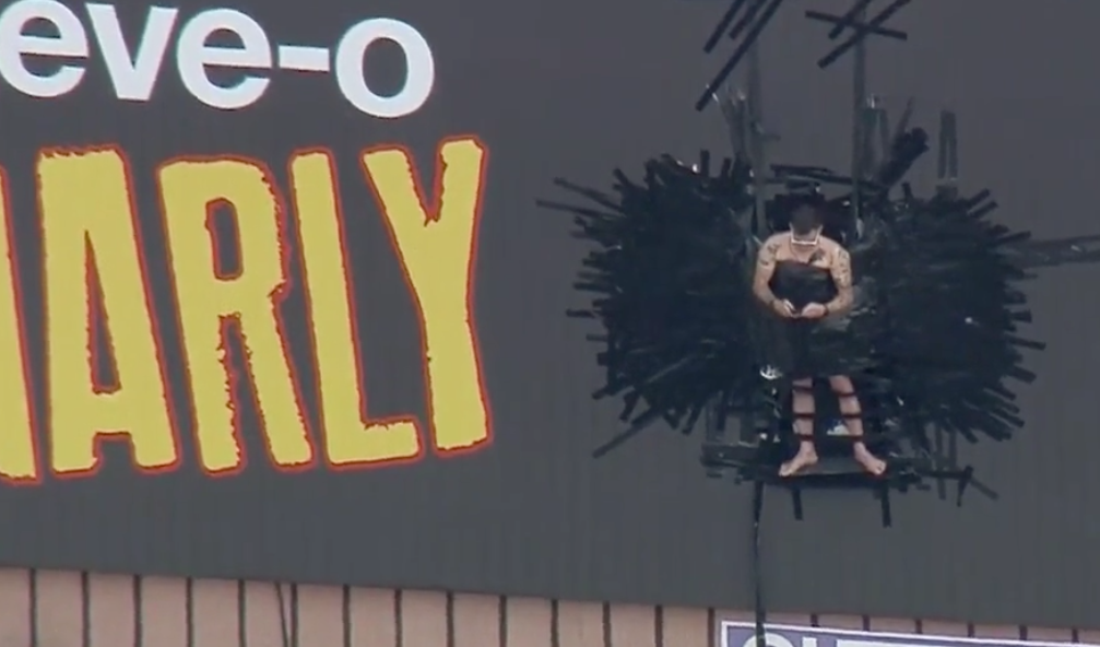 Steve-O taking selfies of the crowd below him while being duct-taped to a billboard