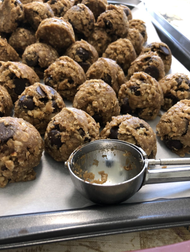 a reviewer photo of cookie dough balls neatly arranged and the same size behind the cookie scoop