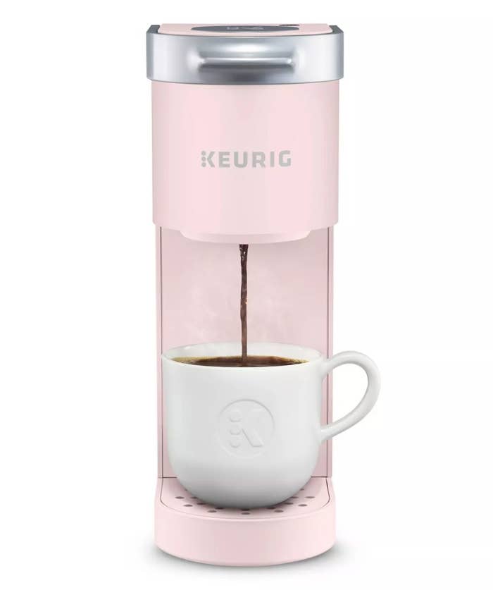 Pale pink Keurig K Mini coffee maker pouring a cup of coffee