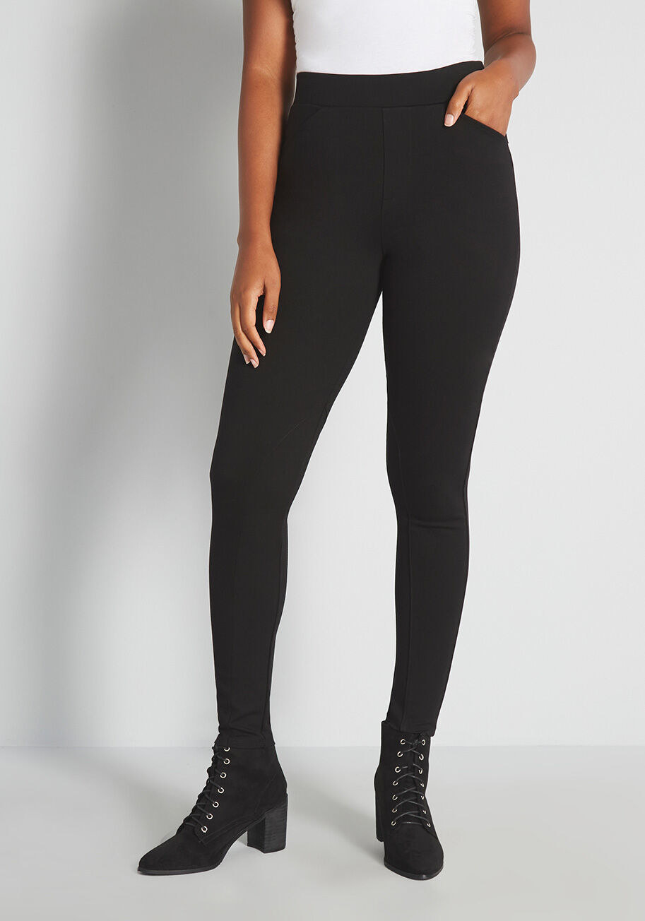 Long black leggings that hits just above the natural waist and has two thin pockets in the front