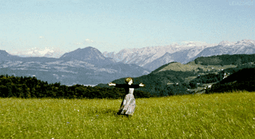 Julie Andrews as Baronin Maria von Trapp, singing in a meadow and turning in circles