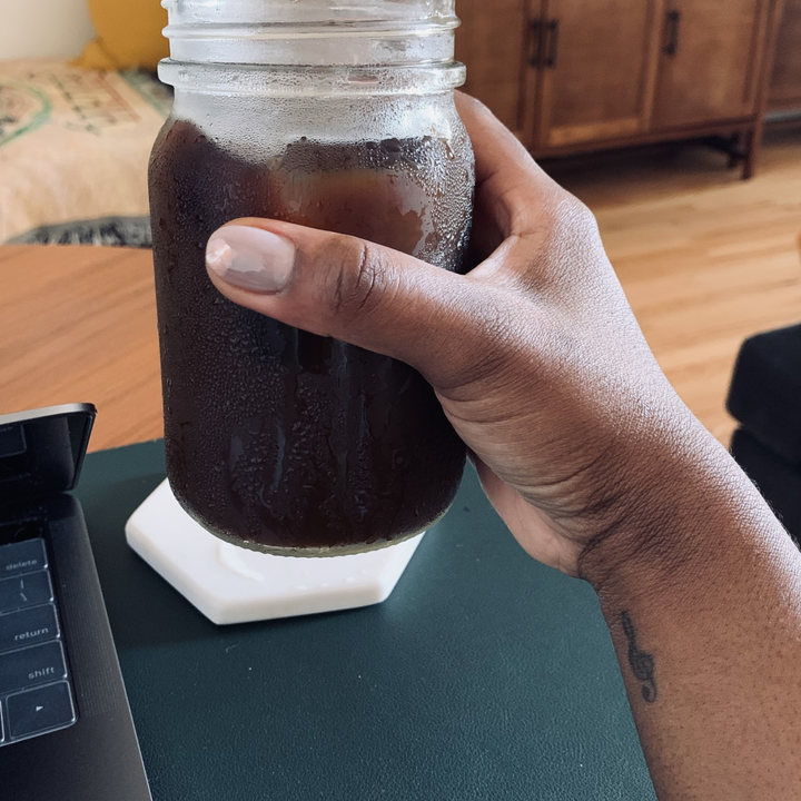 The author holding a finished cup of her iced coffee 