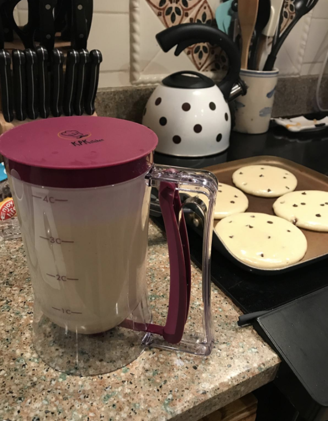 reviewer photo of the batter dispenser next to perfectly round pancakes
