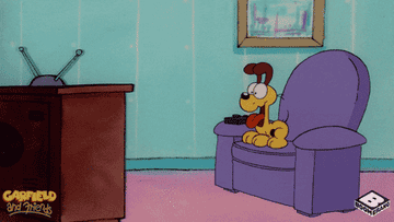 Garfield and Odie from &quot;Garfield&quot; sitting on a purple recliner in front of the TV