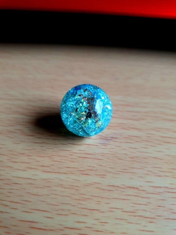 A cracked, bright blue marble resembles a disco ball