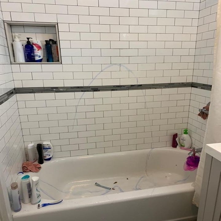 Reviewer's before picture of their slightly yellowed shower tiles 