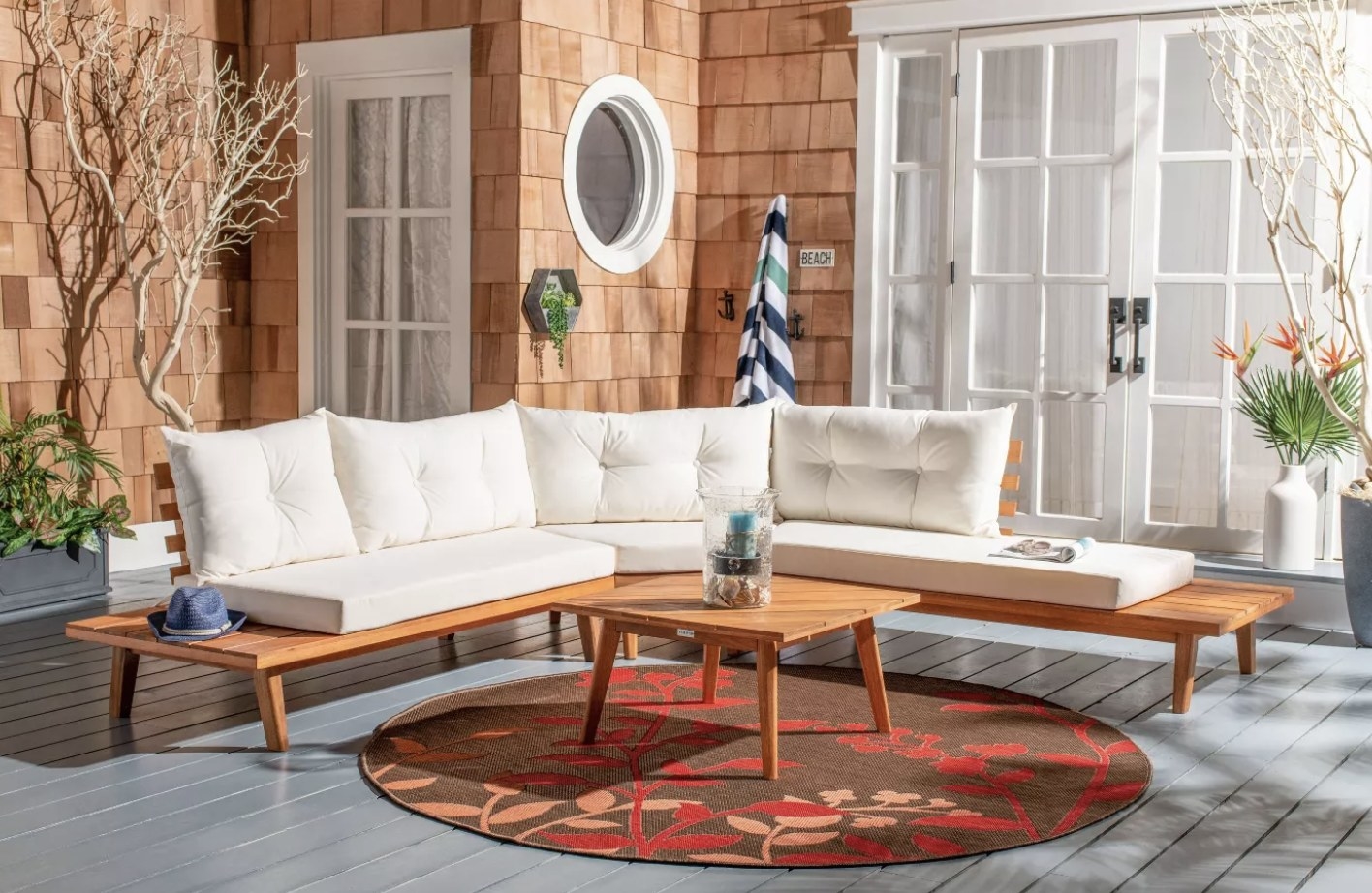 A sectional with benches that extend out to serve as end tables and a matching coffee table on a rug in front of a house
