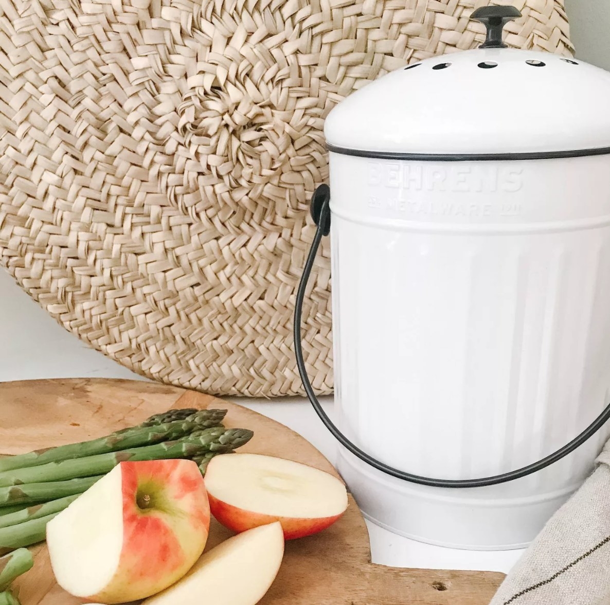 A while metal composter with a black handle and knob