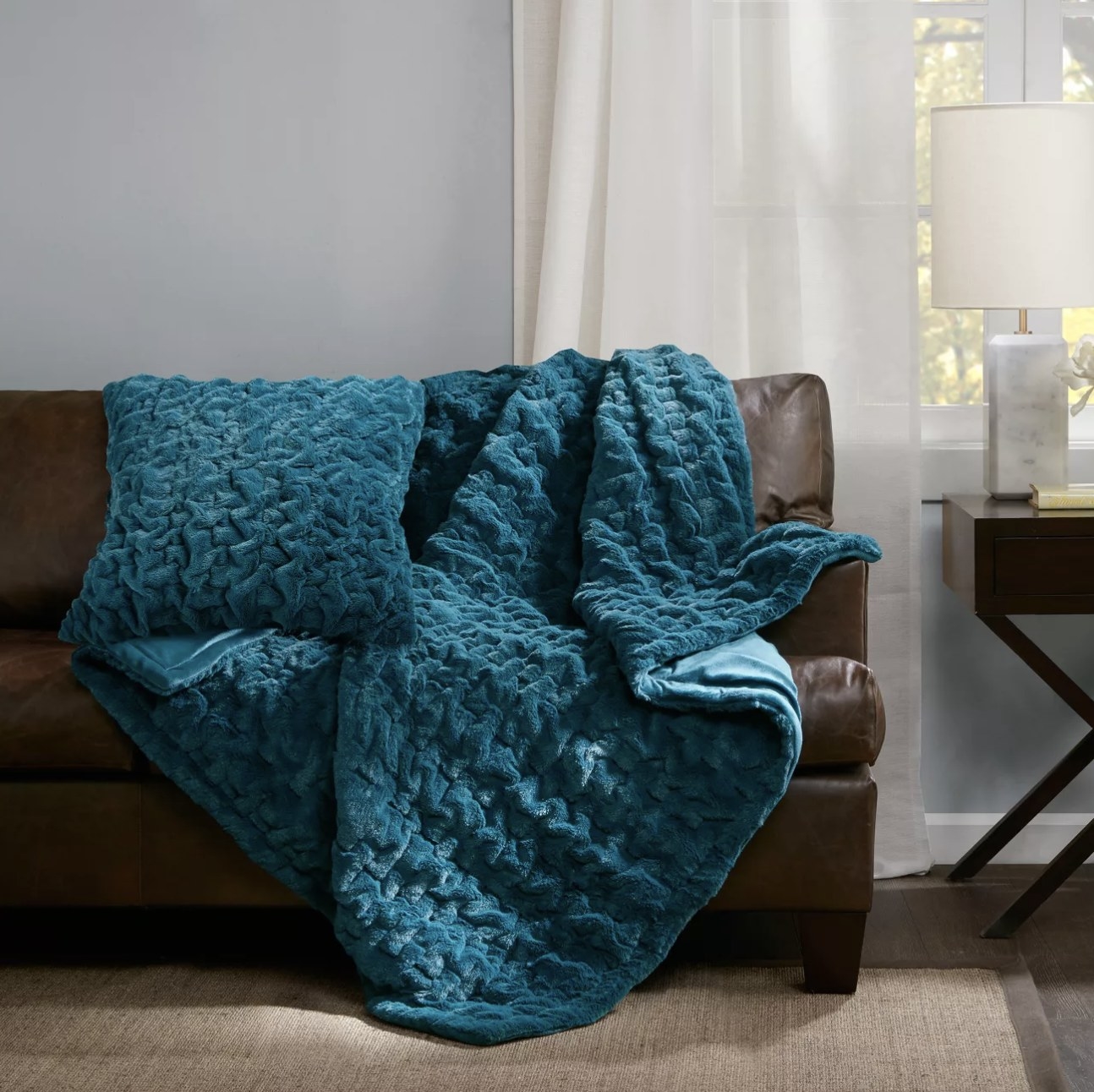 The teal blanket draped on a couch