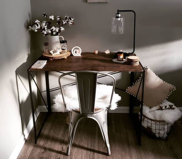 Reviewer pic of the desk with wood top and metal legs in a room