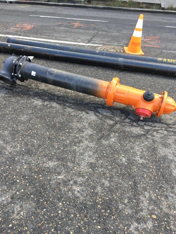 A fire hydrant lays in the street and it&#x27;s much taller than one might accept when it&#x27;s not partially embedded in the ground