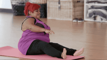 Television personality &quot;Ms. Juicy&quot; attempts to stretch on a yoga mat. 