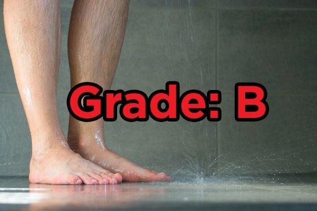 A pair of feet standing in a running shower with the words &quot;Grade: B&quot; over top