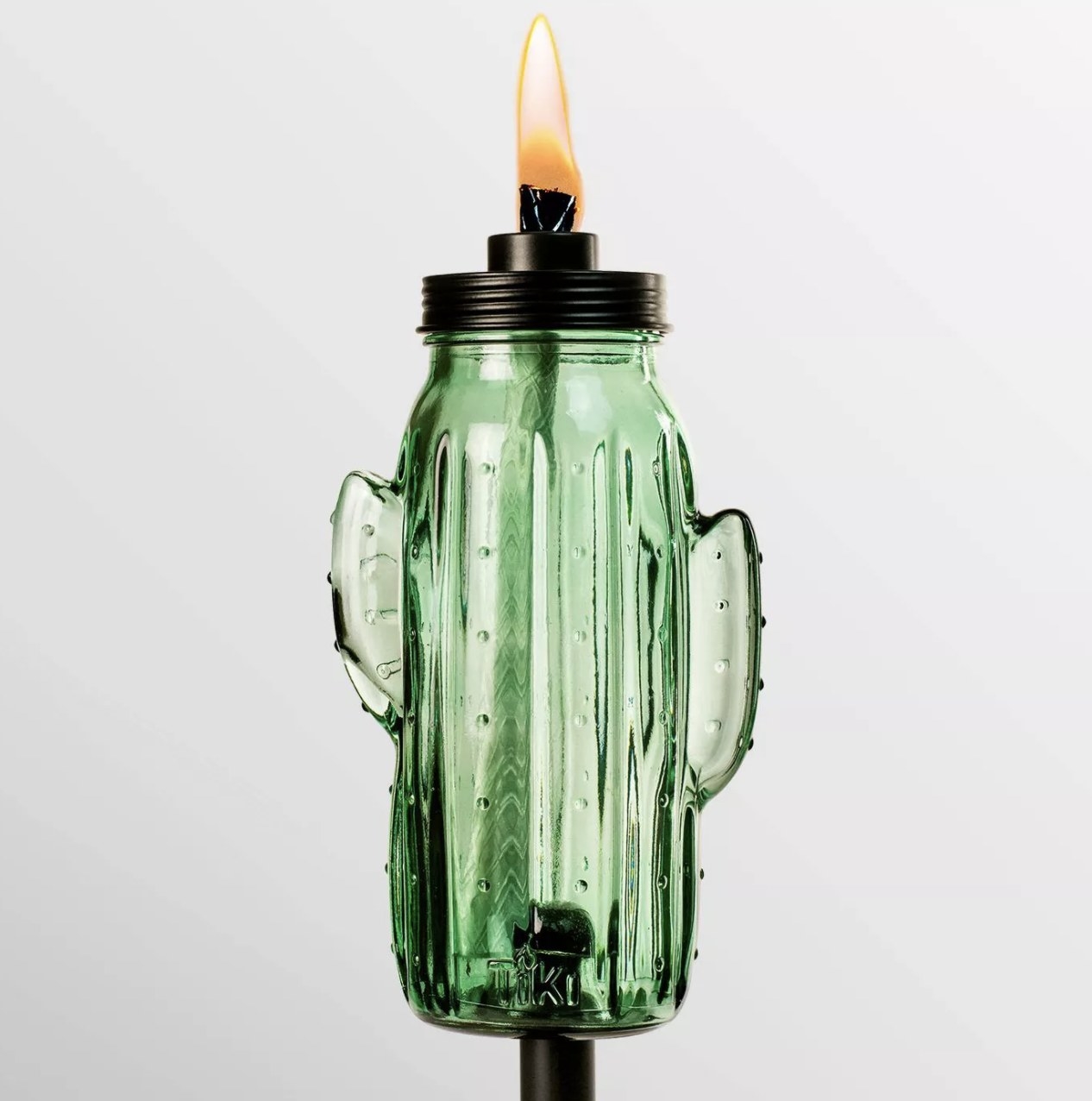 A glass cactus torch with a lit fiberglass wick