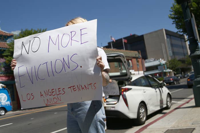 A protester's sign says, "No more evictions. Los Angeles tenants union."