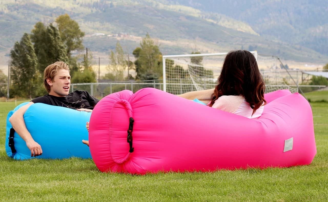 Models sitting in pink and blue inflatable loungers 
