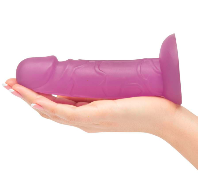 Model holds dark purple suction cup dildo in their palm