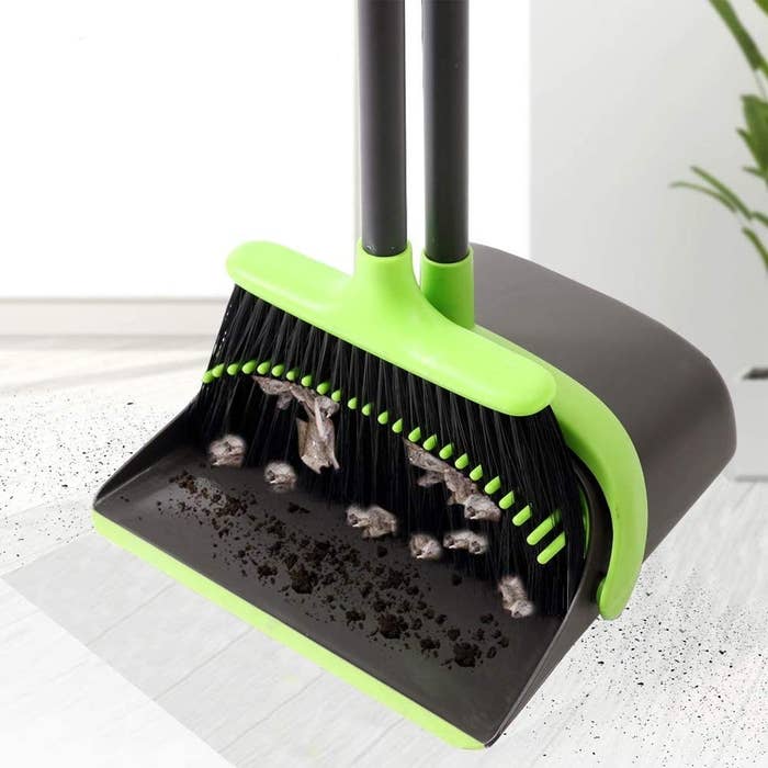 a broom and dustpan set filled with dirt and dust bunnies