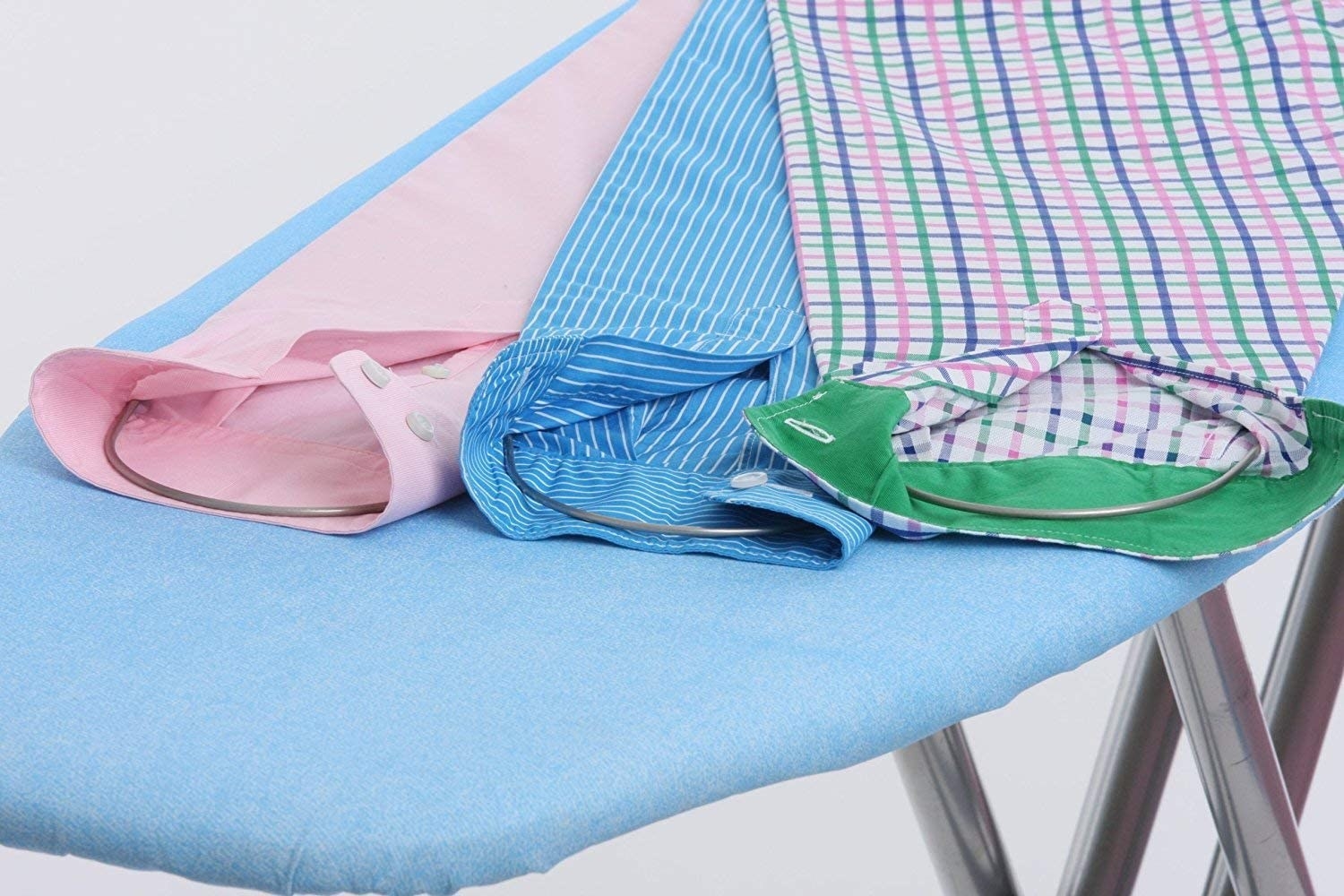 Three dress shirt arms on an ironing board with ironing assistants inside of them