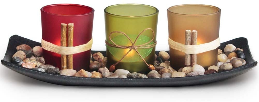 Candle Holder With Rocks and Red, Green, And Yellow Candles.