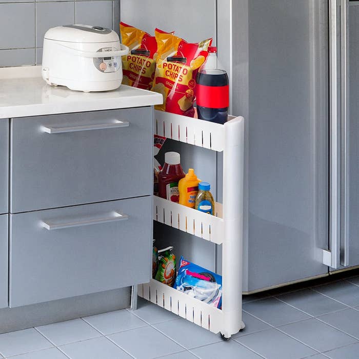 A pull-out storage unit in the gap between a counter and fridge