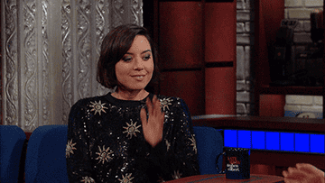 Actress, Aubrey Plaza, leaning forward and cupping her face with her hand