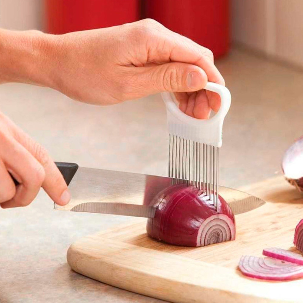Product photo showing person using the tomato/onion vegetable slicer with a kitchen knife to evenly slice a red onion on a cutting board