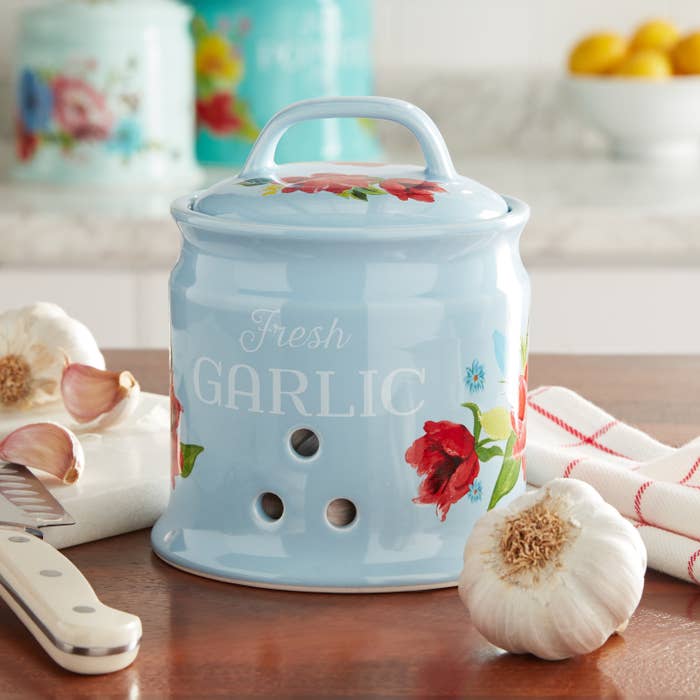 Product photo showing 5.7 inch garlic keeper storage container by The Pioneer Woman in baby blue with decorative flowers