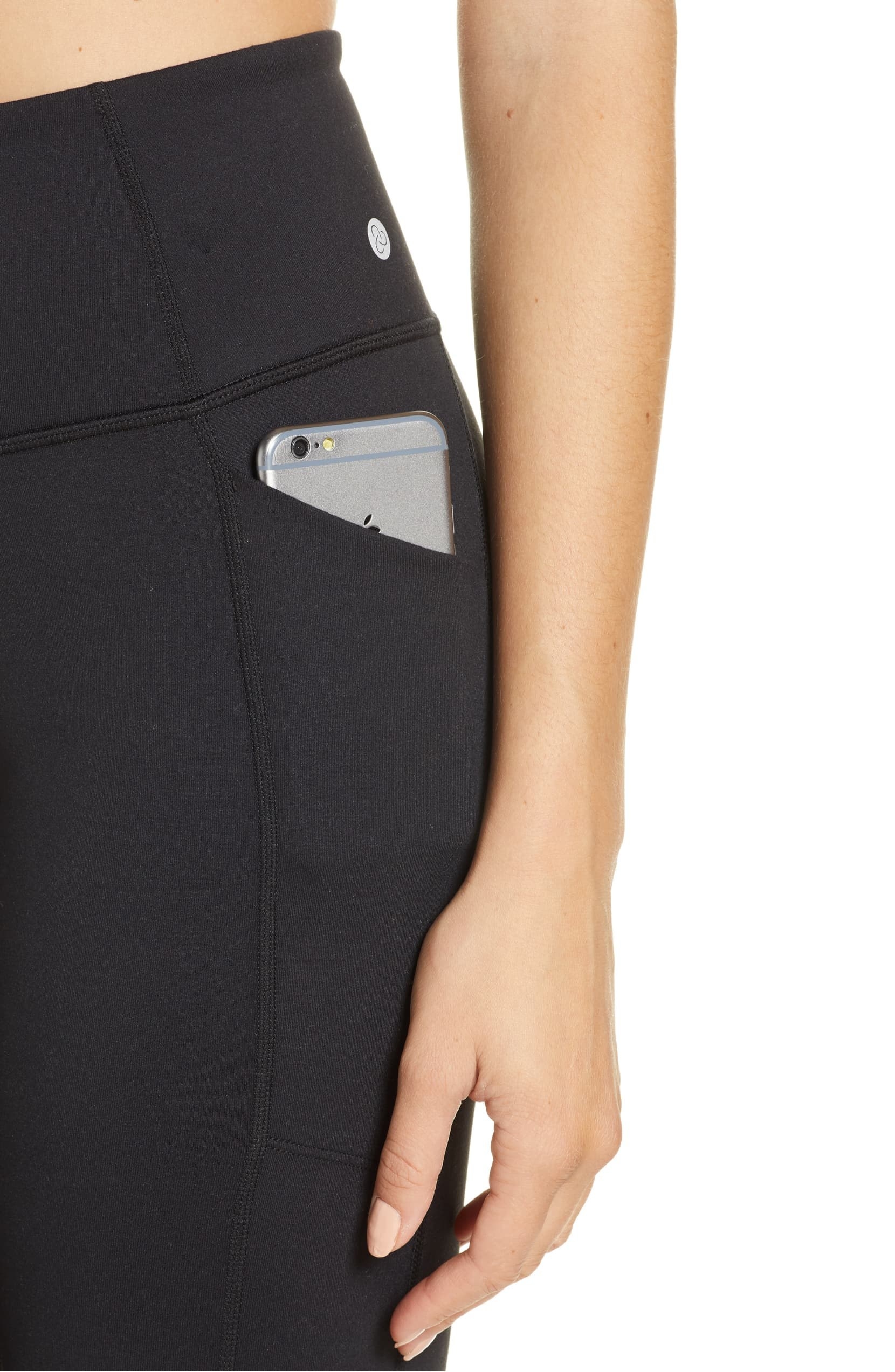 A woman wearing Zella leggings with a phone in the side pocket.