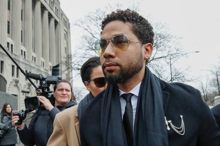 Jussie Smollett walking outside a courthouse with reporters behind him 