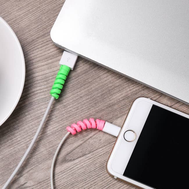 The round coils in lime green and pink around a phone charger cable and laptop charger cable