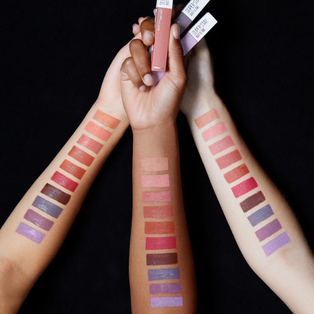 The liquid lipstick swatched on three arms in different skin tones