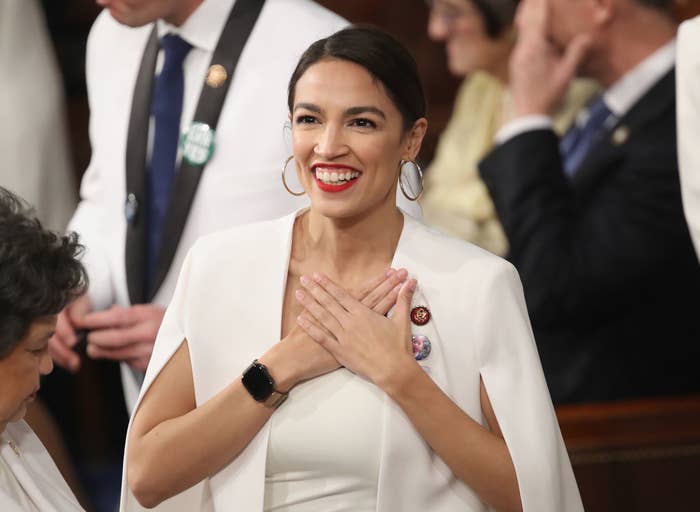AOC smiling with her hands covering her heart