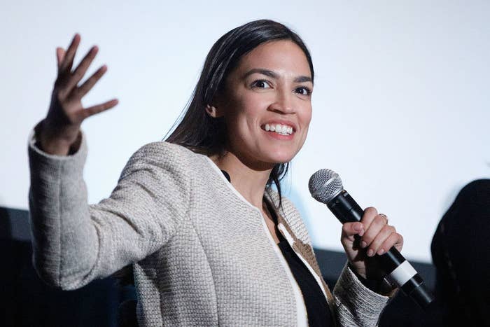 AOC smiling and talking into a microphone