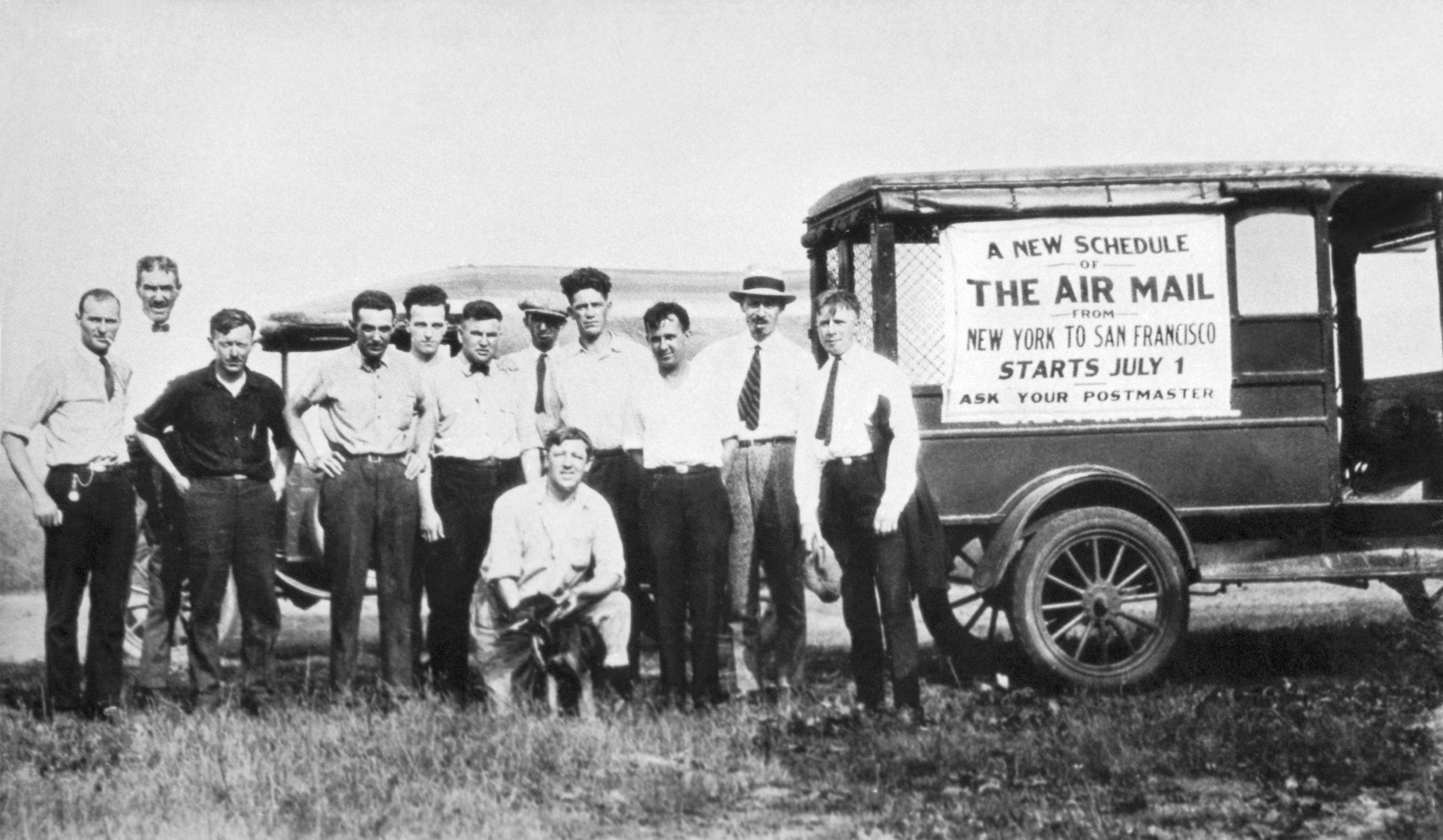 a group of white men in front of a wagon that says US Air Mail