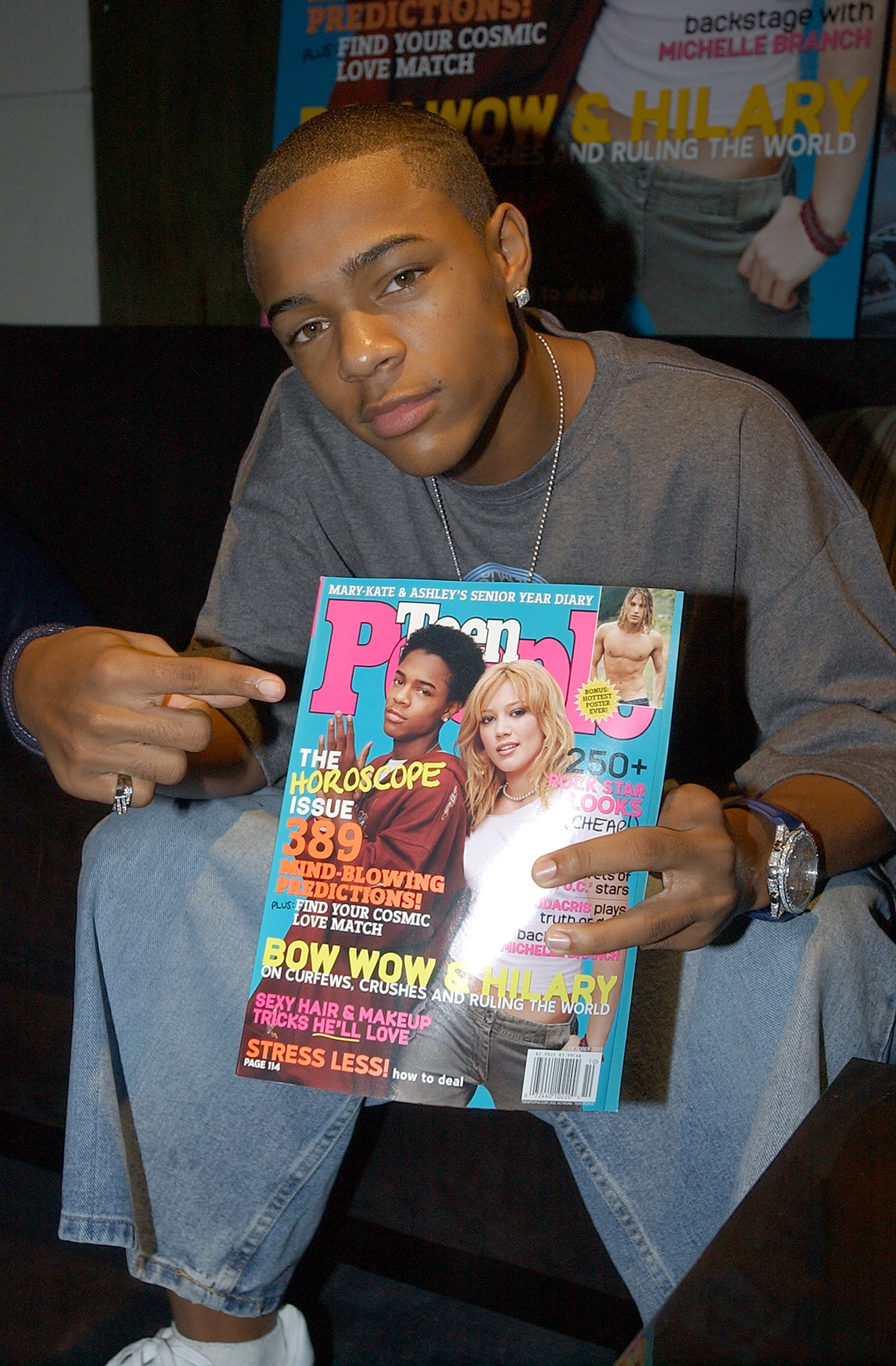 Bow Wow sitting down pointing to a Teen People cover.