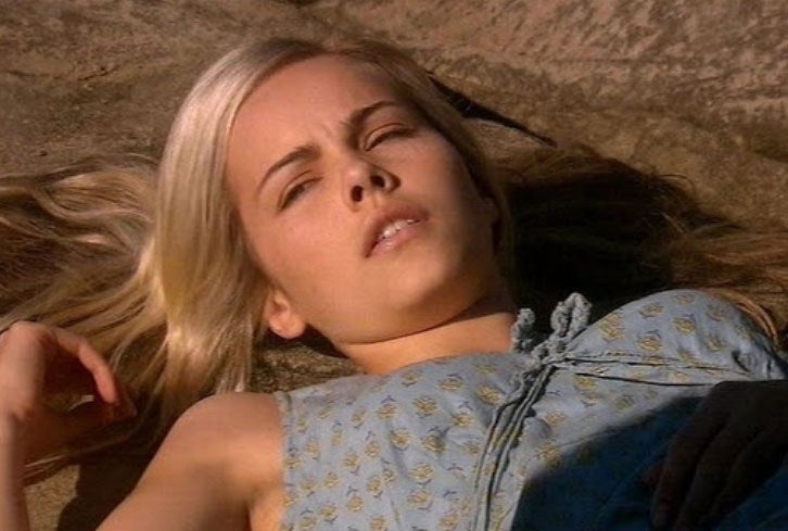 Tasha Andrews lies bewildered on a rock.