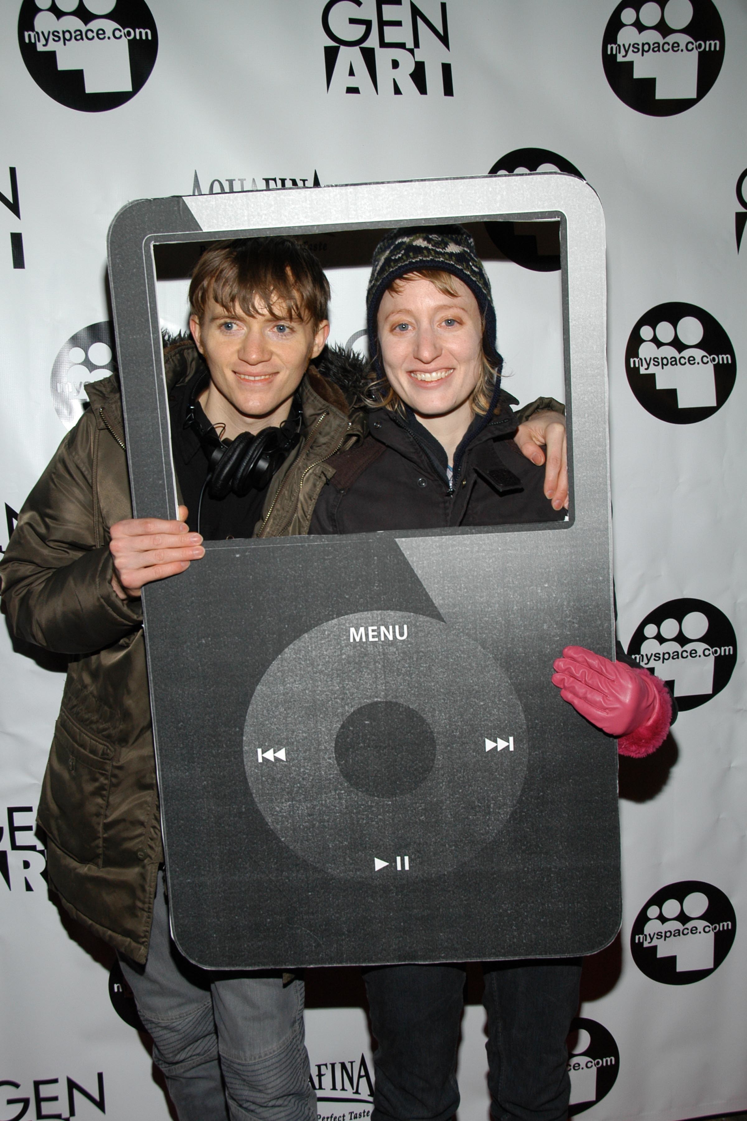 Two filmmakers arriving at the Myspace GenArt event while holding a giant black Classic iPod cutout prop.