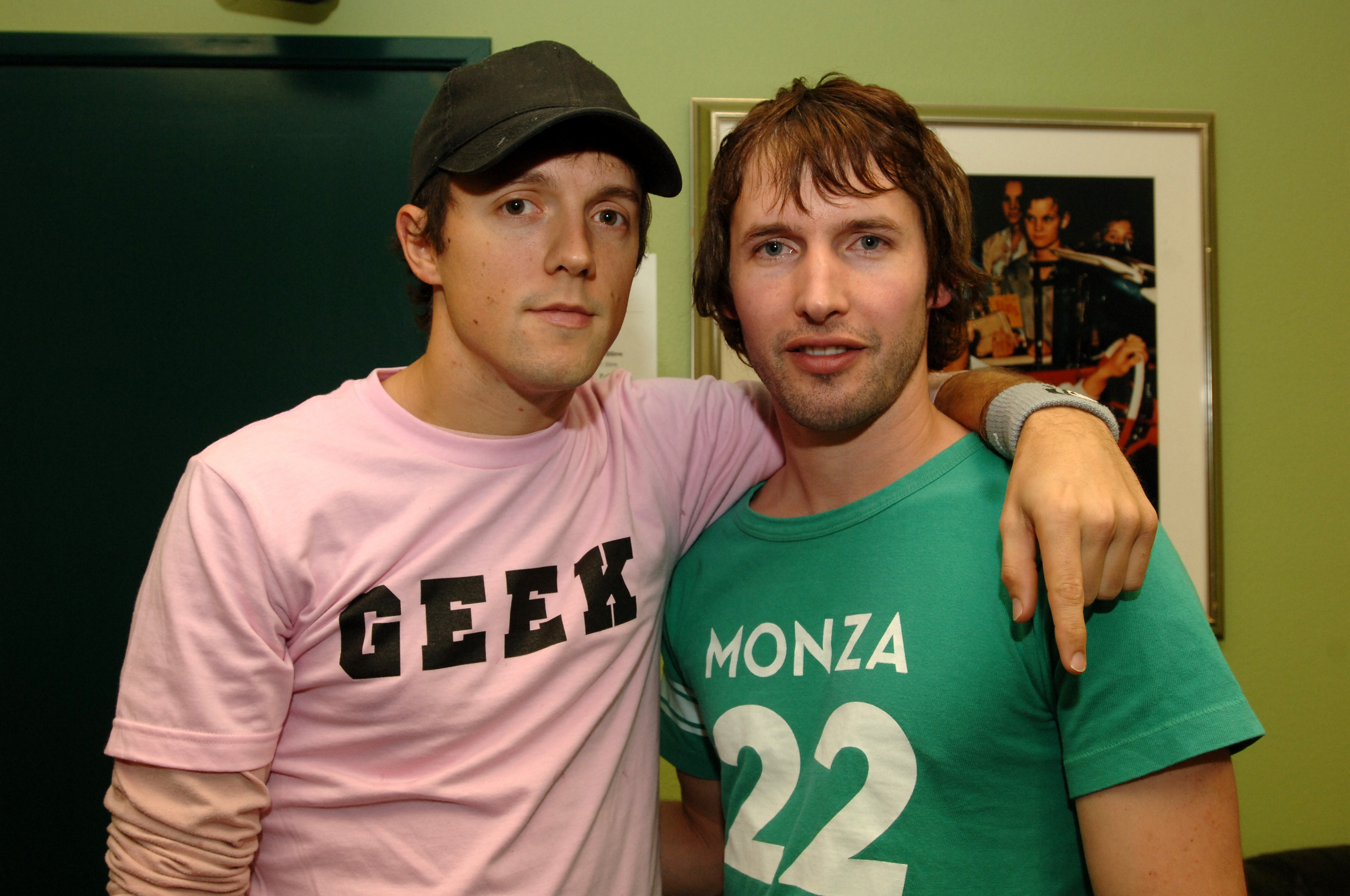 Jason Mraz wearing a black baseball cap and pink T-shirt with &quot;geek&quot; written on it, and James Blunt wearing green vintage looking T-shirt with &quot;Monza 22&quot; written on it.