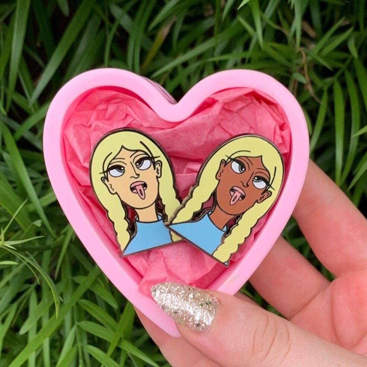 The two pins that look like two girls making funny faces