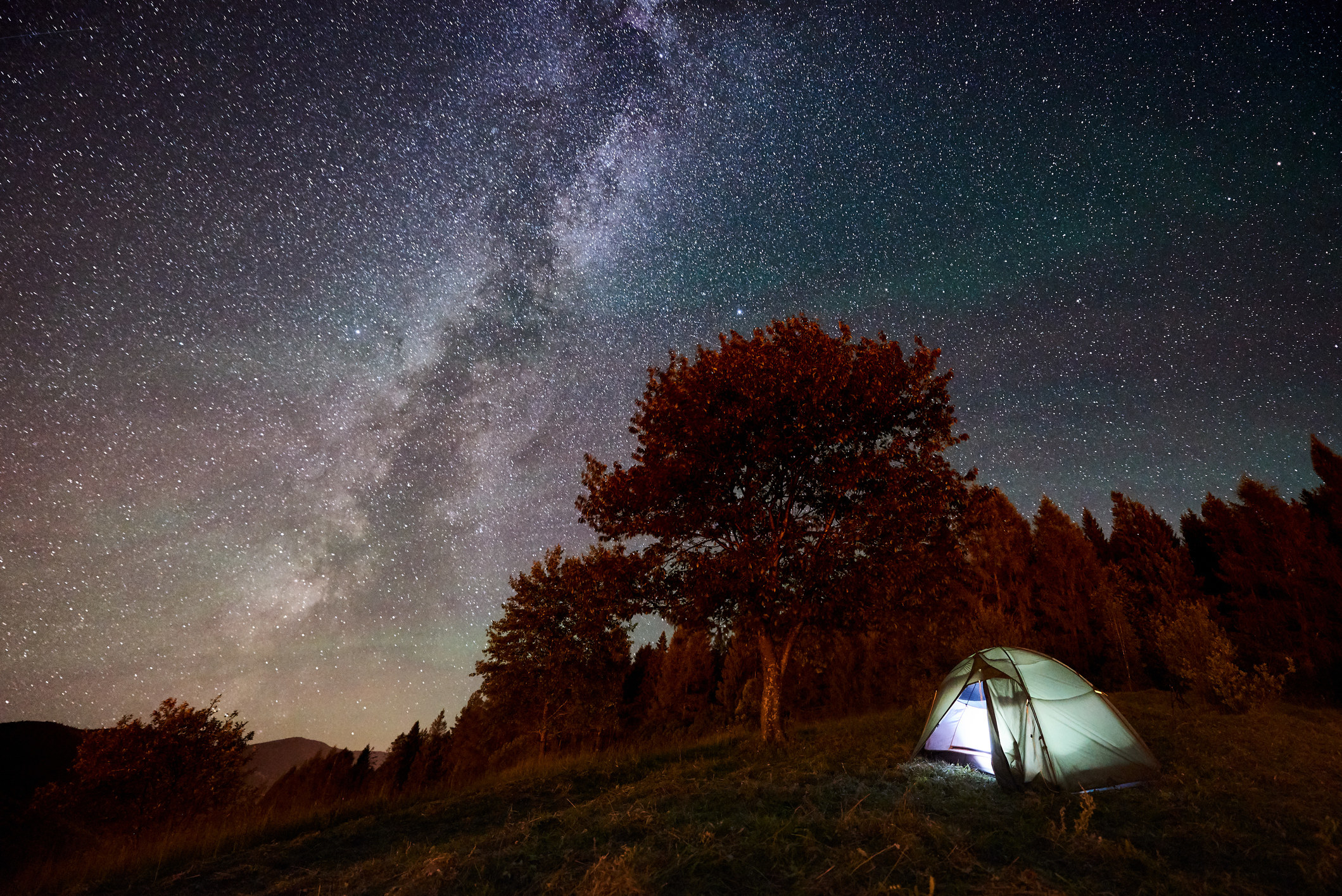 illuminated tent under starry night sky