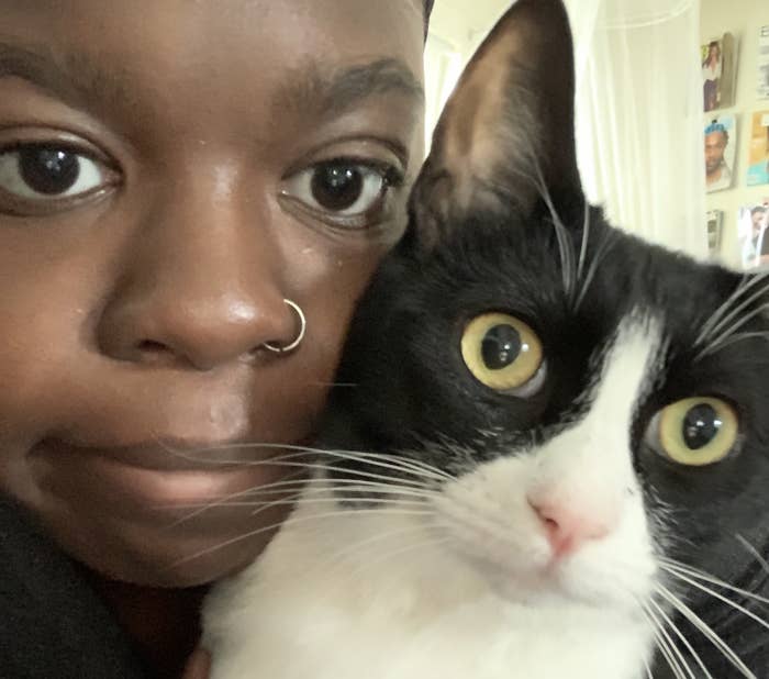 Picture of author, Ehis, holding her cat, Hippo.