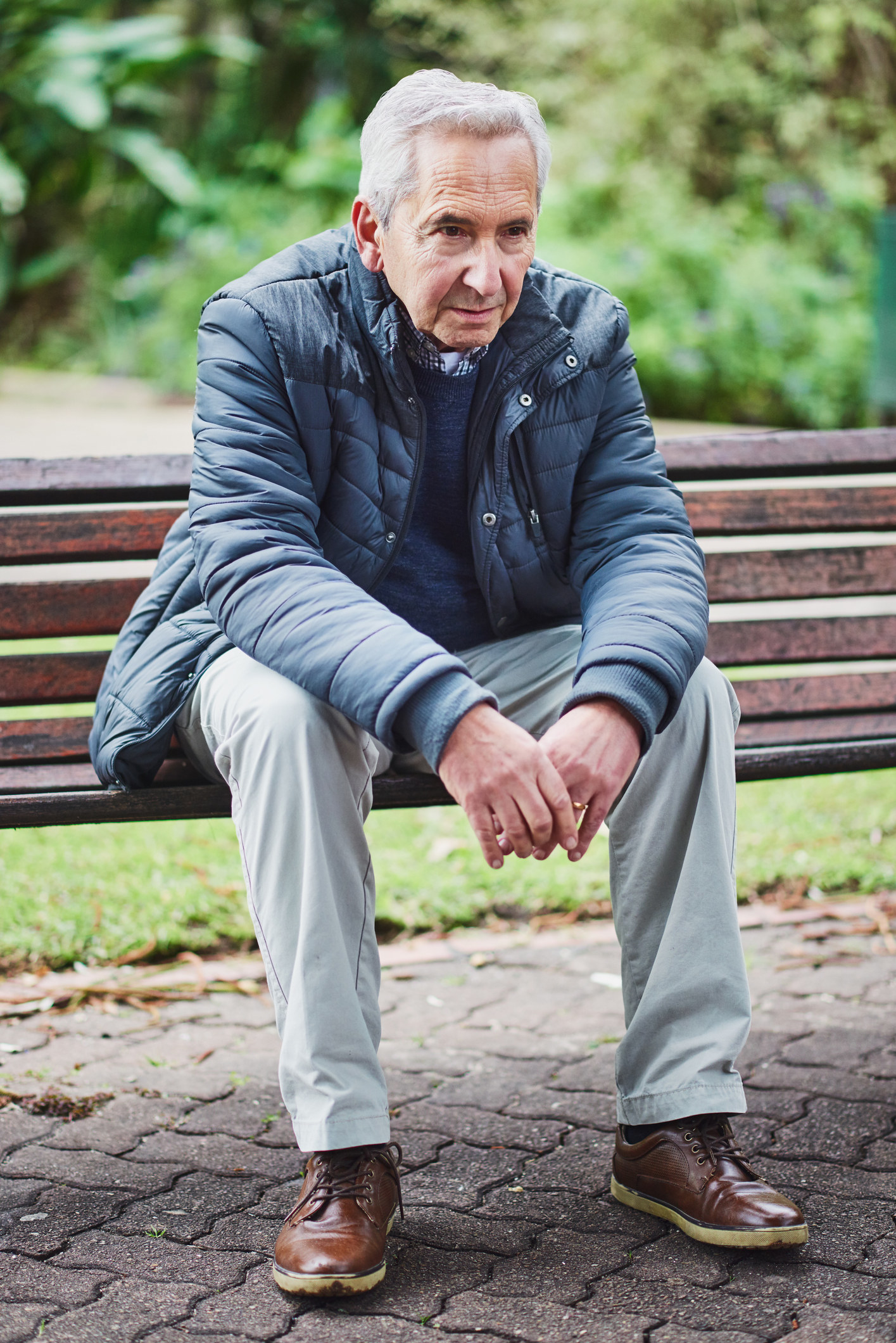 A man sits calmly on a bench