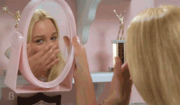 A teenage girl admiring herself in a hand mirror