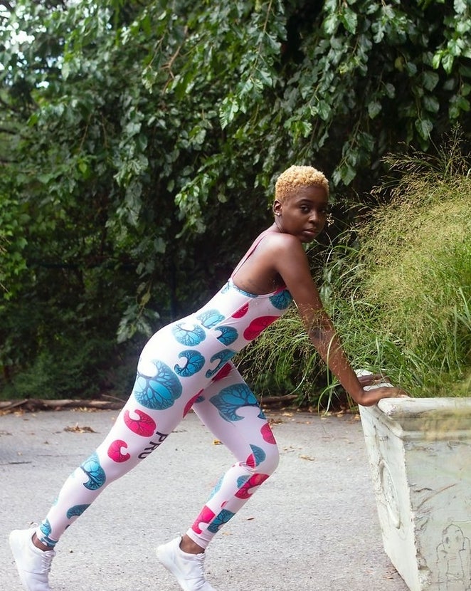 model in white spaghetti strap unitard with blue and pink illustrations of marula trees on it
