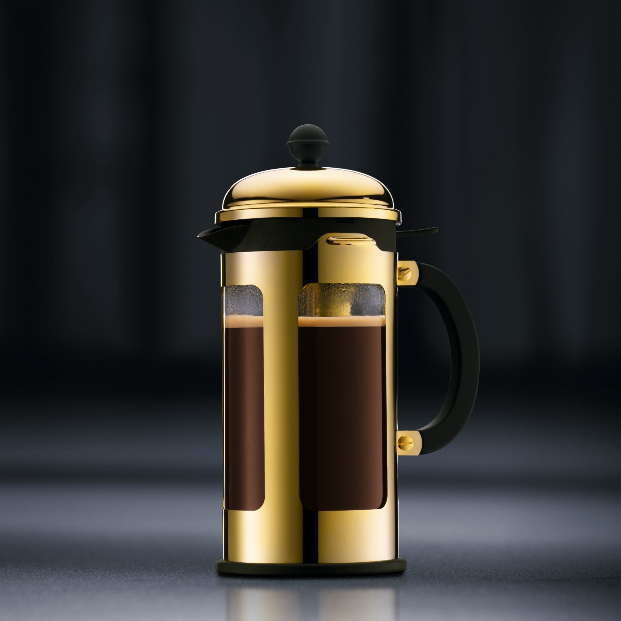 A 17-ounce gold-colored French press with a black hand and top