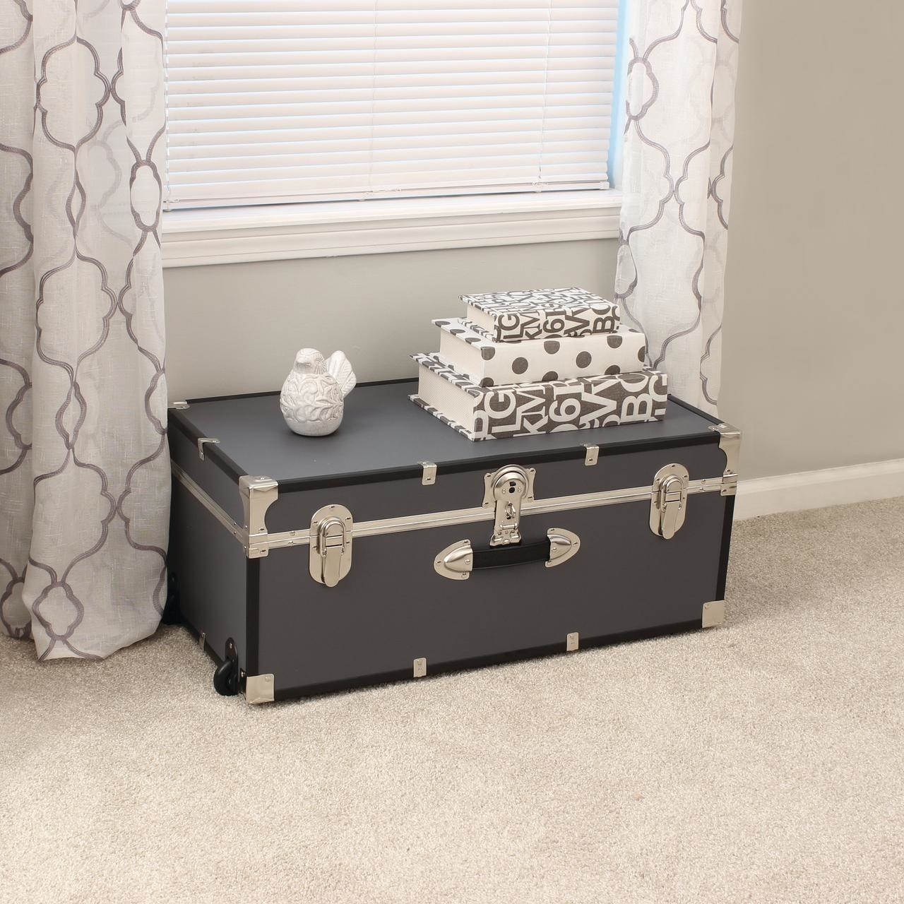 A gray trunk with black wheels and handle and silver accents on corners, edges, and lock