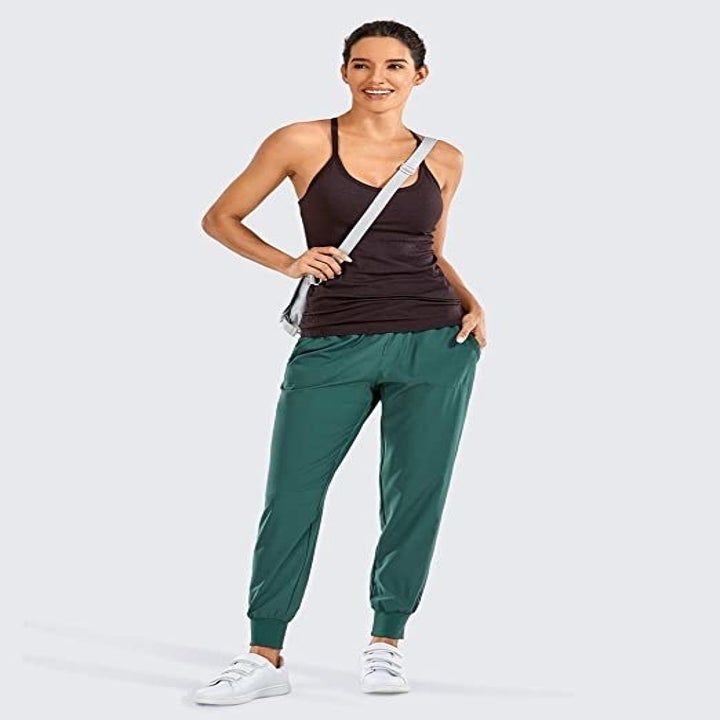 A person wearing the drawstring joggers with a tank top and crossbody bag