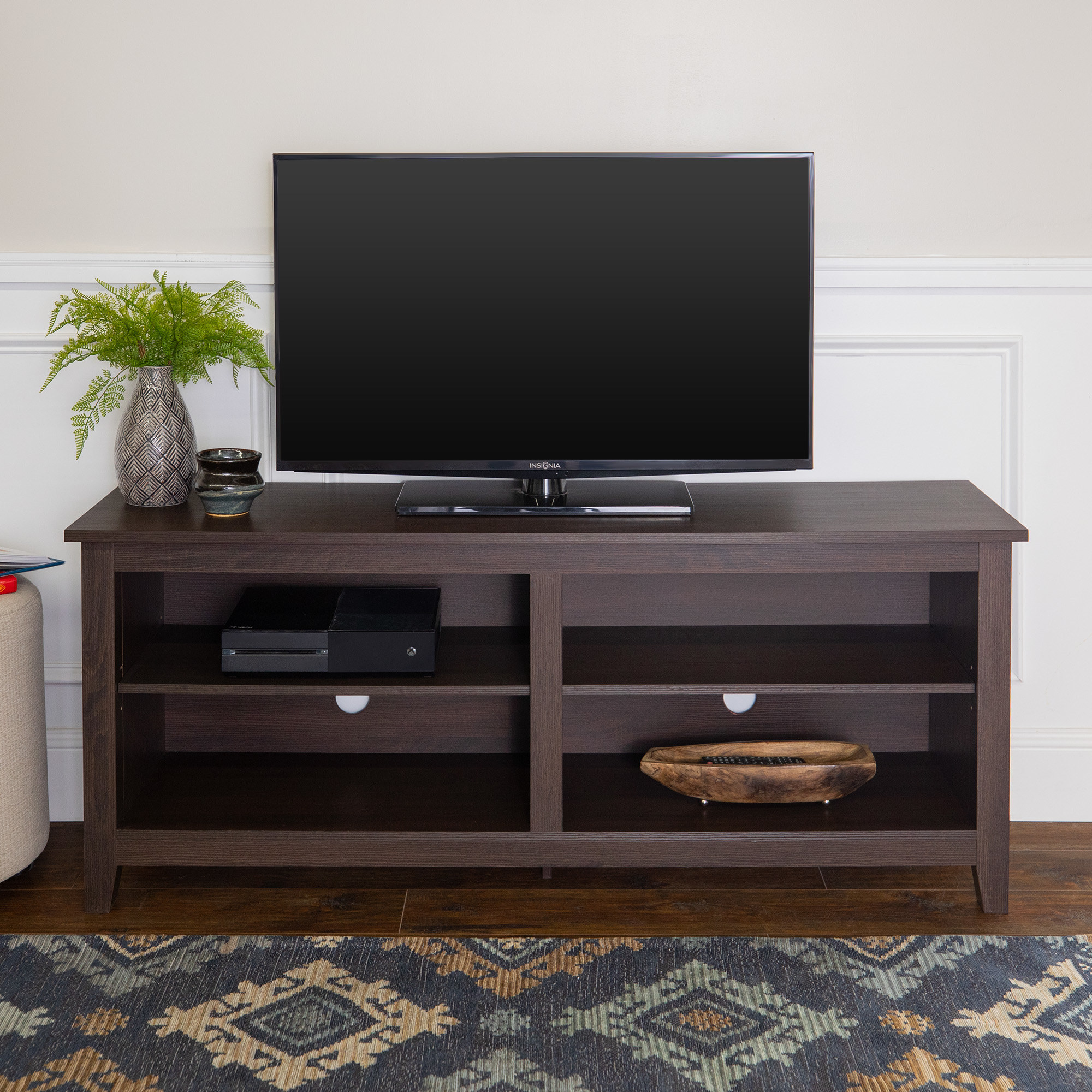 A TV stand with four cubby shelving spaces in an espresso finish
